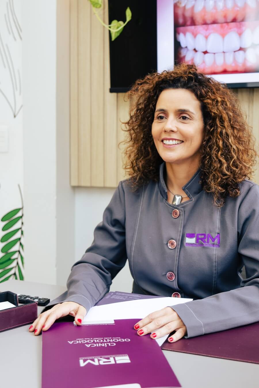 Dentista especialista em periodontia sorrindo em consulta sobre tratamento de gengiva. RM Odontologia Integrativa na Vila Clementino.